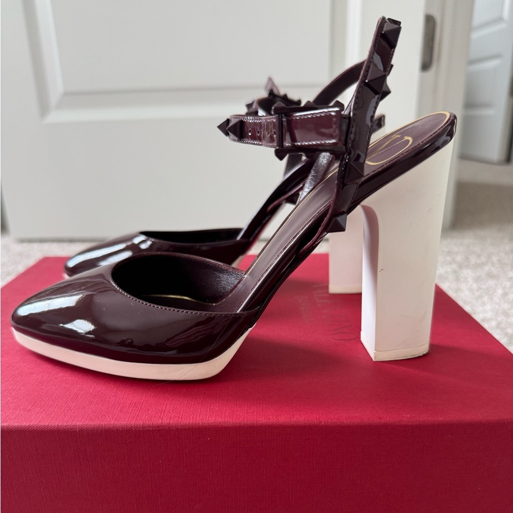 Dark purple patent Valentino pump with rockstud ankle strap. Rubber sole.